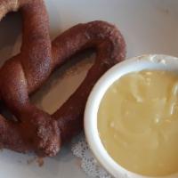 Crabby Pretzel · Baked pretzel dressed in our homemade crab dip and topped with a blend of cheese and old bay
