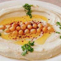 Hummus With Meat · Our famous hummus toppled with halal meat served with pita bread.