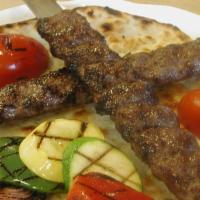 Grilled Ground Beef Kabob (Kubideh) · Two juicy strips of seasoned ground beef. Served with grilled vegetables and tomato on a bed...