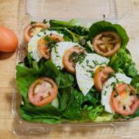 Caprese Salad · Fresh sliced mozzarella with tomatoes on a bed of mixed greens. Sprinkled with basil and dri...