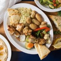 #5. Chicken Kabob · Breast of chicken on a bed of rice, with veggies and pita bread.