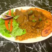 Curry Goat · Served with steamed white rice, waakye, or jollof rice. Salad and fried plantains (2) included