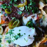 Bolos Nachos · Corn tortilla chips smothered with homemade chorizo, chile verde, bolo beans, jalapeños and ...