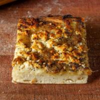 Caramelized Onion Focaccia · Our focaccia topped with caramelized onion, poppy seeds and feta cheese