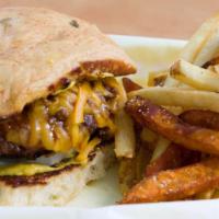 Crestview Burger · A chili cheeseburger topped with chili, cheddar cheese, sliced onions, and mustard on a toas...