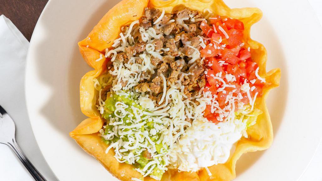 Taco Salad · A crisp flour tortilla with ground beef and beans. Topped with lettuce, sour cream, pico de gallo, jalapenos, and grated cheese.