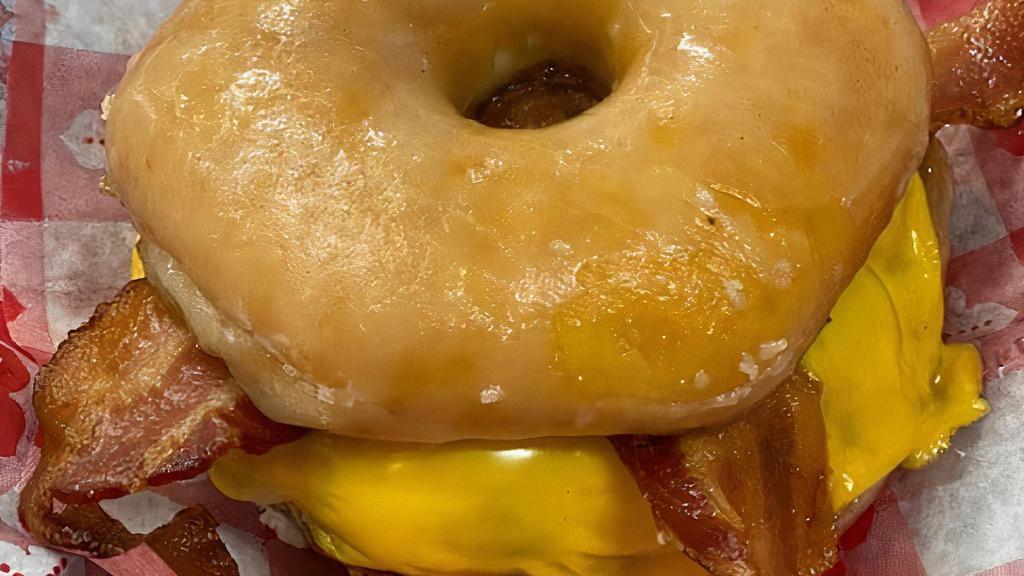 Doughnut Bacon Burger · A full 1/3 pound 100% all beef hamburger served with 2 applewood slices of crispy bacon and smothered under 2 slices of melted American Cheese, served on a slices buttered toasted glazed donut.