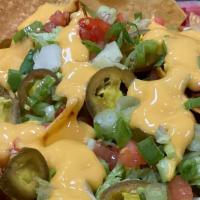 Loaded Nachos · Fresh made chips loaded with chili, nacho cheese, lettuce, tomato, sour cream, and jalapenos.