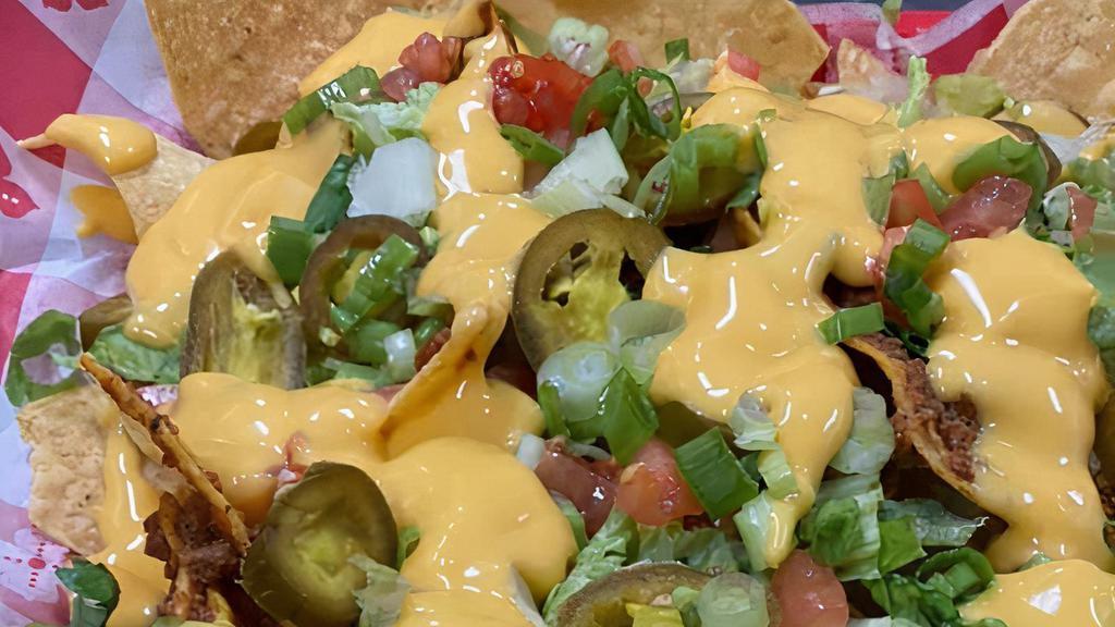 Loaded Nachos · Fresh made chips loaded with chili, nacho cheese, lettuce, tomato, sour cream, and jalapenos.