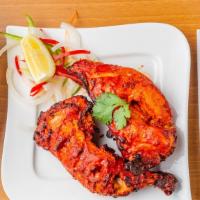 Murgh Tandoori · Yogurt-marinated chicken cooked over hot coals in a special clay oven called a tandoor.