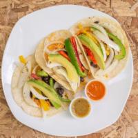 Veggie Tacos · Three corn tortillas with rice, black beans, grill peppers, guacamole and hot sauce on the s...