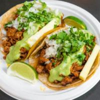 Al Pastor Tacos · 2 guajillo marinated pork tacos served on warm corn tortillas with onion, cilantro, avocado ...