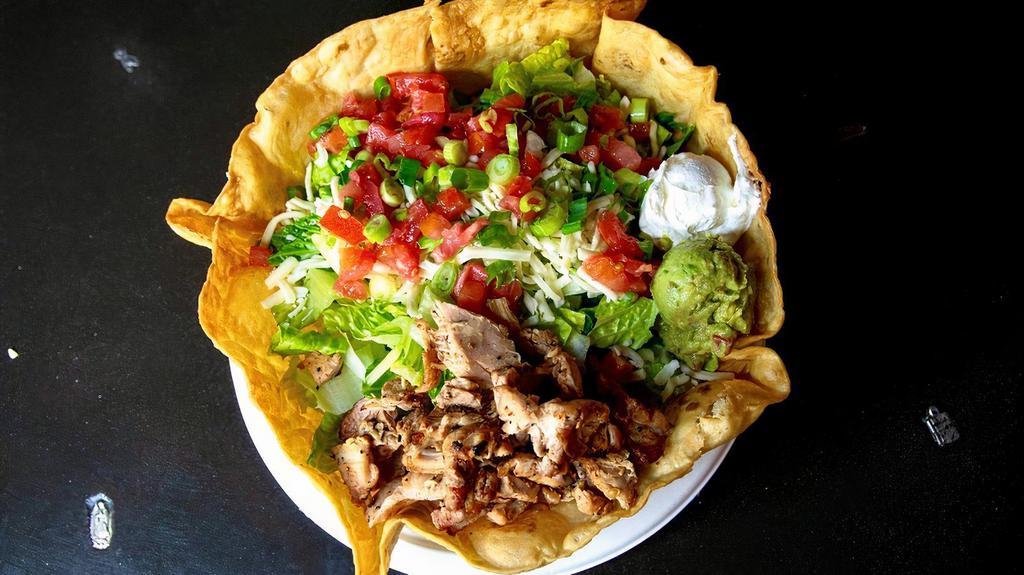 Grilled Chicken Salad · A large deep fried tortilla bowl filled with grilled chicken on a bed of rice & beans, topped with lettuce, tomato, scallions, guacamole and sour cream.