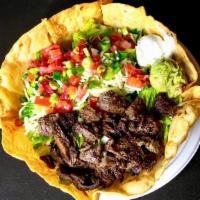 Grilled Skirt Steak Salad · A large deep fried tortilla bowl filled with grilled skirt steak on a bed of rice & beans, t...