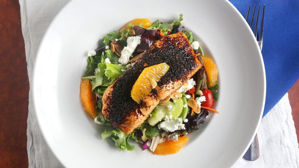 Brown Sugar Salmon Salad · Brown sugar-ancho chile crusted Atlantic salmon, roasted on a cedar plank, over mixed greens, red cabbage, carrots, cucumbers, cherry tomatoes, fresh orange, toasted almonds and goat cheese, tossed in our raspberry vinaigrette.