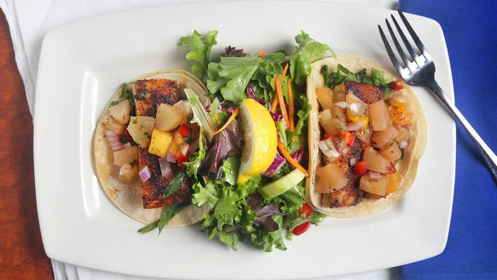 Blackened Mahi Tacos · Two corn tortillas stuffed with blackened mahi-mahi, fresh spinach and tropical fruit salsa, served with mixed greens tossed in ginger-lime vinaigrette.