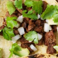 Steak Taco · Steak fajita, with grilled onions topped with cilantro with a slice of lime.