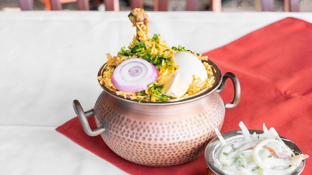 Dum Chicken Biryani · The perfect delicacy of made with the choicest cuts of chicken, dum cooked with saffron hued basmati rice.