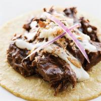 Mole Poblano · Shredded chicken in a nutty poblano mole, topped with queso fresco, crema red onion and sals...