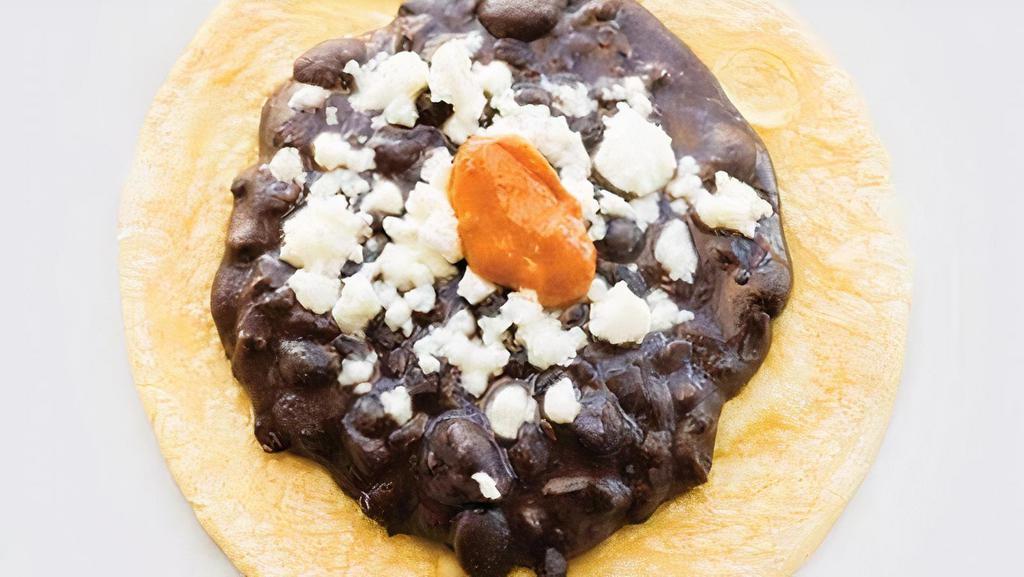 Frijoles Con Queso · Black beans topped with queso fresco and chipotle chile.