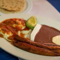 Desayuno Ranchero / 2. Ranchero Breakfast · Dos huevos estrellados con salsa ranchera, plátano frito, frijol, crema, queso, aguacate y d...