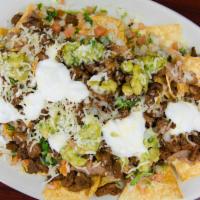 Nachos · Crispy tortilla chips covered with melted oaxaca cheese, beans, guacamole, sour cream and pi...