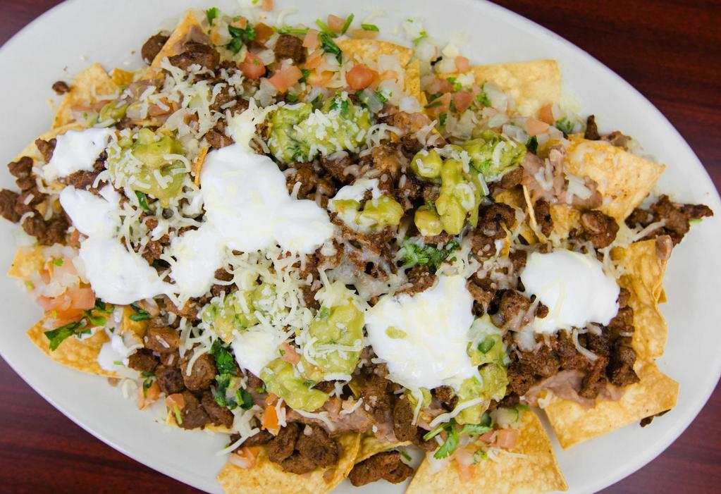 Nachos · Crispy tortilla chips covered with melted oaxaca cheese, beans, guacamole, sour cream and pico.