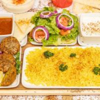 Falafel Over Rice · Delicious crispy falafels on a bed of rice with tomatoes, onions, greens, and salad cooked t...
