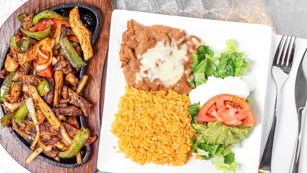 Fajitas · Choice of steak or Chicken grilled with onions, tomatoes, and bell peppers. Served with spinach rice, refried Beans, sour cream, and guacamole salad, choice of flour or corn tortillas.