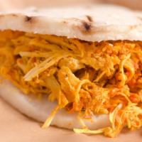 Chicken Arepa · An arepa (corn patty) stuffed with shredded chicken, melted cheese, crushed potato chips, cr...