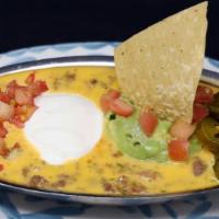Large Queso Compuesto · Our Chile Con Queso, topped with fresh guacamole and taco meat.