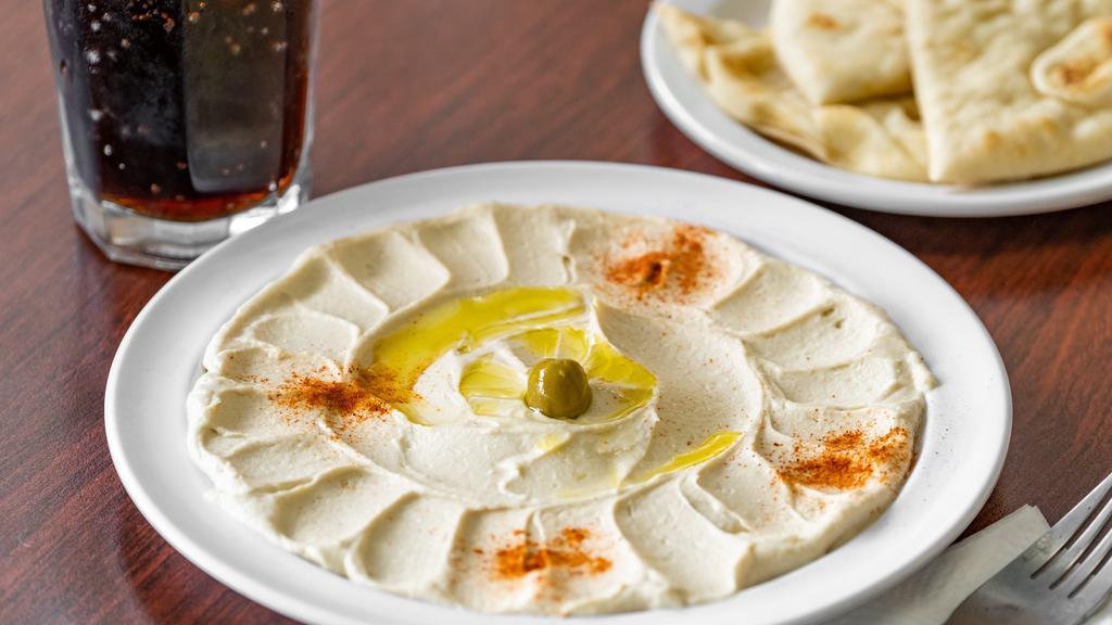 Hummus Plate · Garbanzo beans, tahini, lemon juice, garlic, garnished with olive oil, paprika and black olives. Served with pita bread.