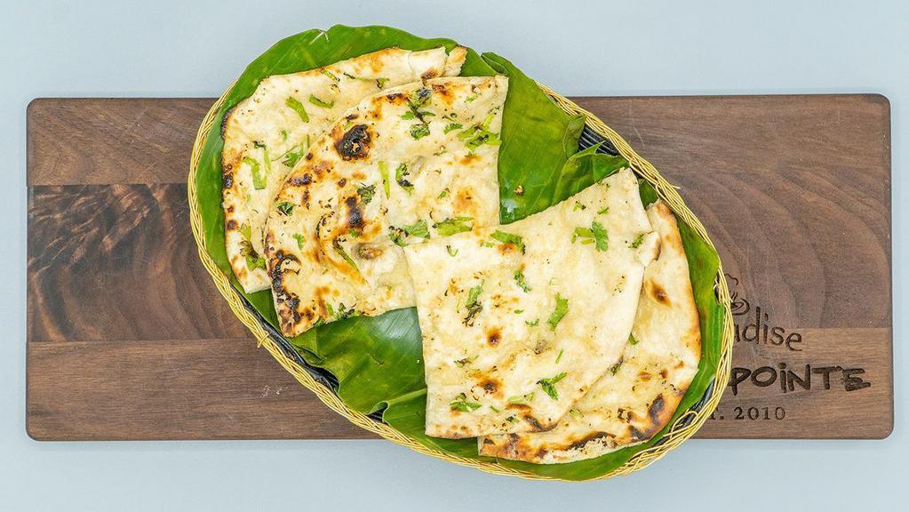 Garlic Naan · Aromatic and scrumptious, leavened, tandoor-baked white bread of refined white flour, topped with squashed garlic and green coriander.