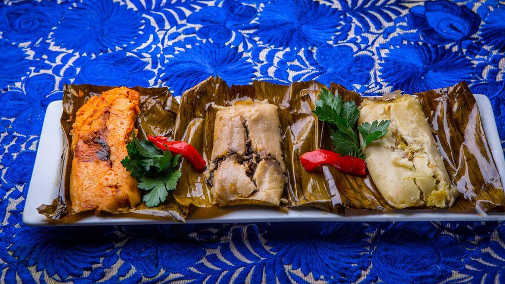 Tamales Oaxaqueños · Three banana leaf-wrapped tamales - pork, chicken and portobello with cuitlacoche.