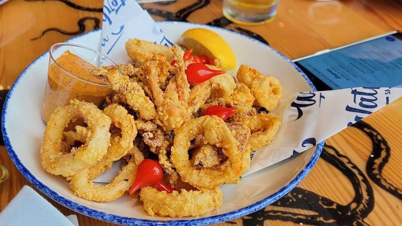 Fried Calamari · cornmeal-crusted calamari rings & tentacles, Chistorra chorizo, pickled peppers, ancho remoulade, lemon wedges.