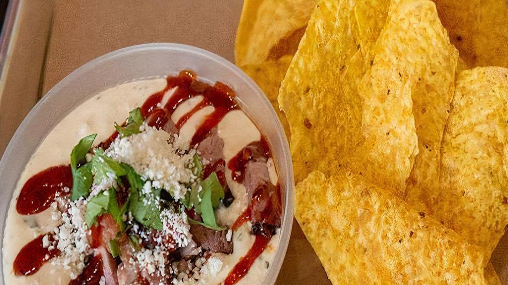 Brisket Queso · You guest it! Brisket, Cheese, Cilantro, Bbq Sauce, Cotija Cheese with house made tortilla chips.