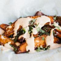 Not So Sweet Potato Wedges · Sweet potato wedges, roasted and fried to perfection, topped with harrisa sour cream, queso ...