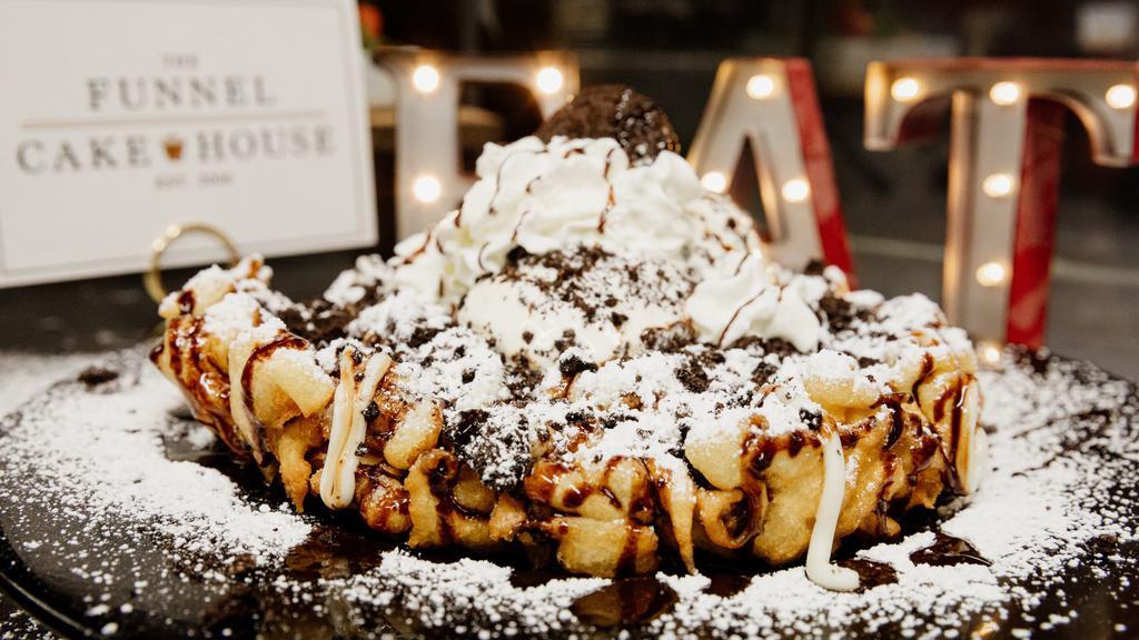 “The King”  Oreo Cookie Cheesecake Funnel Cake · Freshly prepared funnel cake, sprinkled with powdered sugar, cream cheese drizzle, delicious cheesecake bites, crumbled oreo cookies, topped with chocolate drizzle and whole oreo cookies (add whipped cream for a total chocolate experience)