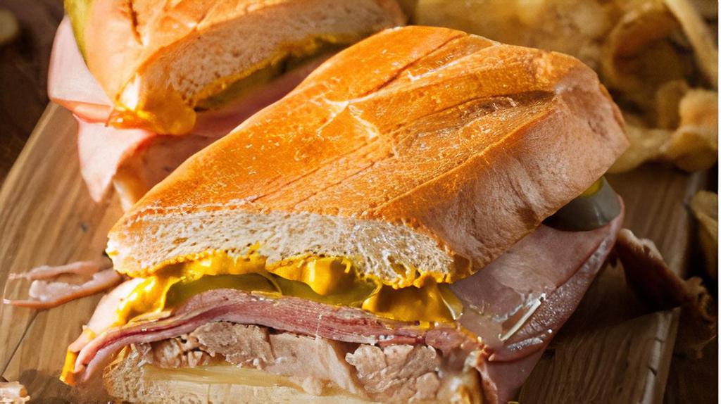 Cuban Sandwich · Pulled pork, honey ham, mustard and pickle with your choice of cheese on white bread. Comes with Chips and a Pickle.