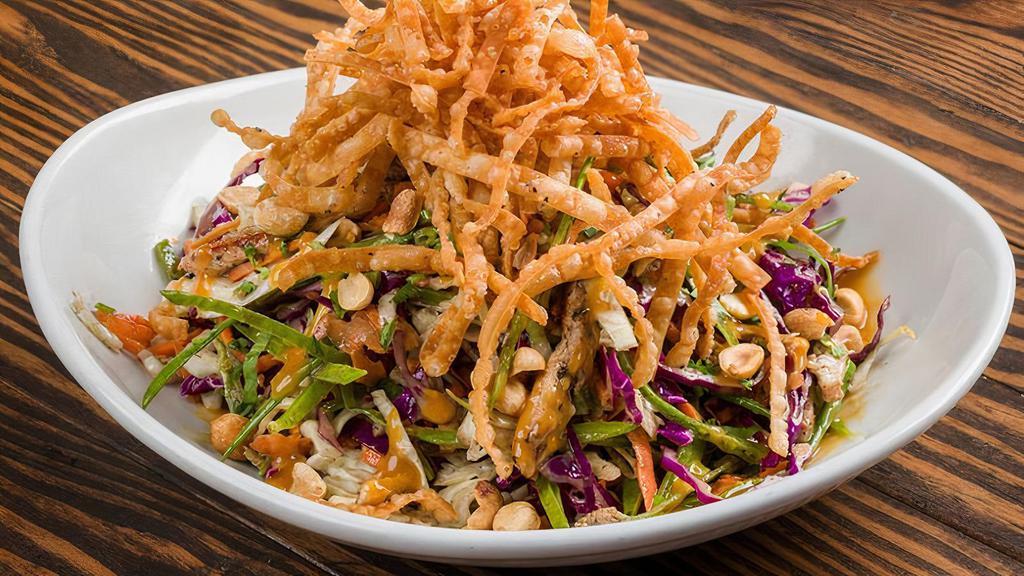 Asian Chicken Salad · Red & Green Cabbage, Snow Peas, Carrots, Grilled Chicken, Peanuts, Cilantro, Wonton Strips, Sesame Ginger Vinaigrette, Peanut Butter Dressing