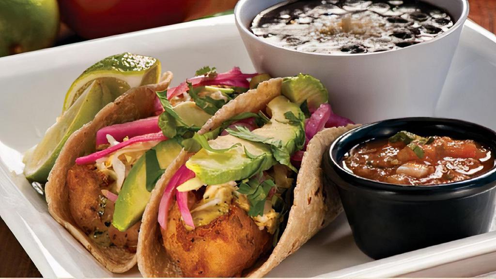 Baja Beer Battered Fish Soft Tacos · Chipotle Slaw, Avocado, Marinated Red Onions, Cilantro, Salsa. Served with Black Beans & Limes.