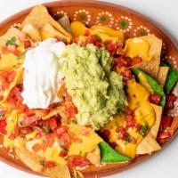 Nachos Tex Mex  · Fresh tortilla chips topped with cheddar cheese sauce, jalapenos, pico de gallo, guacamole &...