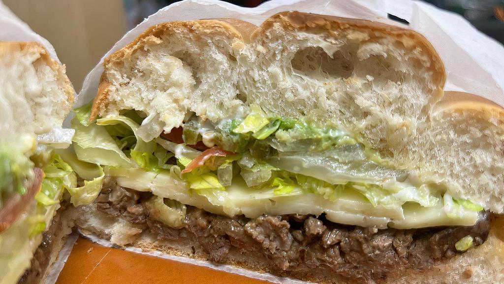 Torta · A traditional Mexican sandwich made with carne asada, refried beans, cheese, lettuce, tomatoes, jalapeños, onions, avocado
