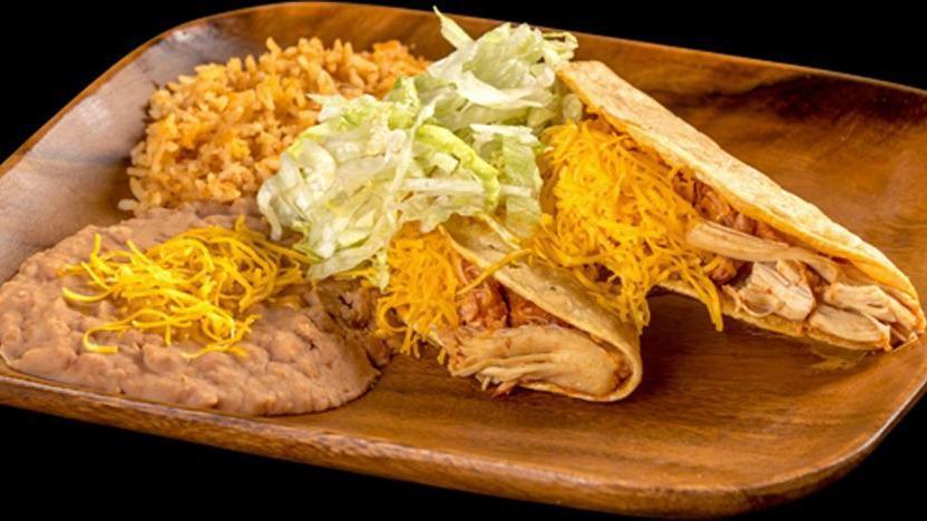 Two Chicken Tacos · Two hard shell chicken tacos with lettuce and cheese served with rice and beans.