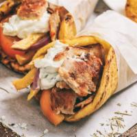 Pork Souvlaki Sandwich · Chunks of seasoned grilled pork wrapped in a pita with lettuce, tomatoes, and onions. Served...
