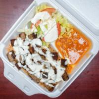 Lamb Over Rice · Grilled Lamb served over brown rice with a side of chickpeas and salad and white sauce on top