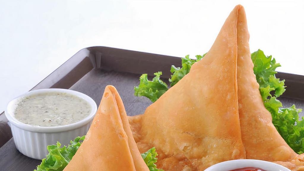 Samosa (2 Pieces) Vegan · Fried pastry with a savory filling, such as spiced potatoes, onions, peas and other spices.