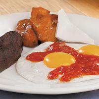 Guatemalteco · Two eggs cooked sunny-side up and topped with ranchera sauce.  Accompanied by refried beans,...