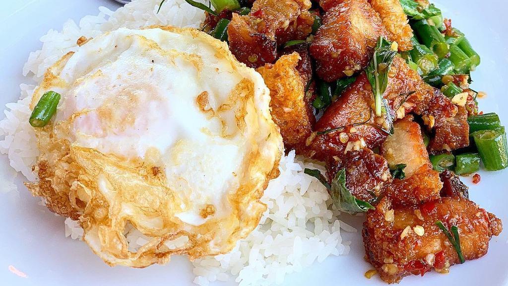 Crispy Pork W/ Basil · (กะเพราหมูกรอบไข่ดาว/Kra Pao Moo Grob) Crispy pork belly cooked with green beans, basil, garlic, and chilies. Served with a fried egg and jasmine rice.