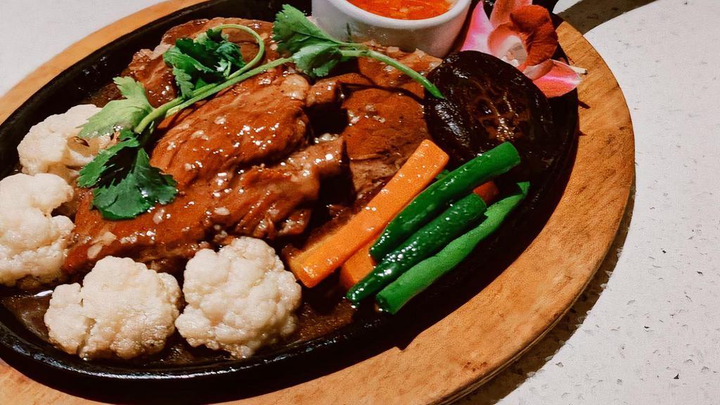 Sizzling Thai Braised Pork Ribs · (ซี่โครงหมูอบจานร้อน เสริฟพร้อมข้าวหอมมะลิ) Sizzling Thai Braised Pork Ribs homemade tender spare ribs in garlic and black pepper served with jasmine rice.